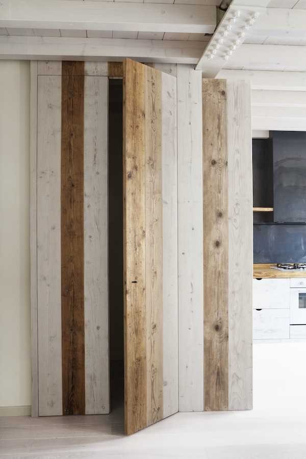Дверь в шкаф из дерева разных оттенков подчеркивает натуральность материалов отделки кухни.