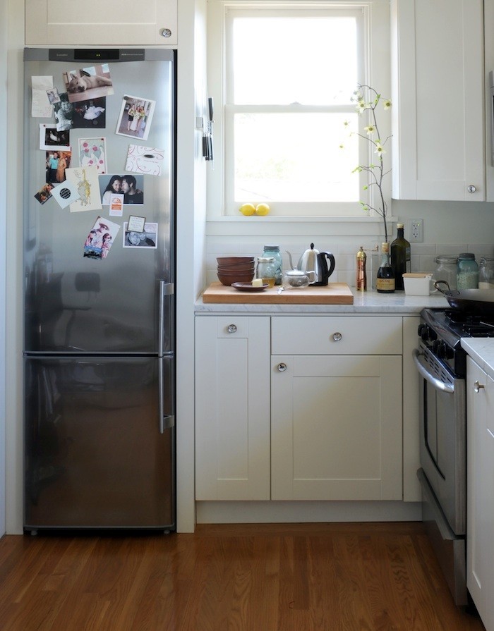 В маленькой кухне есть смысл поставить холодильник меньшего размера, а пространство над ним использовать для хранения кухонных принадлежностей или для микроволновой печки.