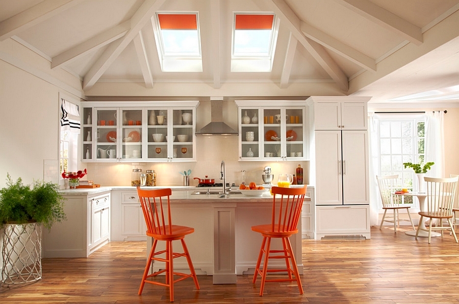 Совпадение цвета рулонных штор на мансардных окнах, барных стульев и некоторой посуды объединяет интерьер этой кухни.